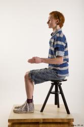 Sitting reference of whole body striped blue gray shirt blue jeans shorts black gray shoes Wesley